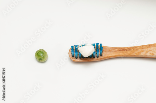 Bamboo wood toothbrush with the recommended size of toothpaste equivalent to a pea