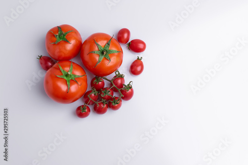 Grape or cherry tomato branch. Pile of red grape and normal tomatoes, isolated on white background, soft light © Romualdo