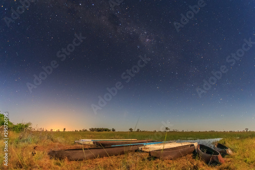 Botswanian local mokoro boats under the starlite sky, on the shore of delta Okavango river, Botswana photo