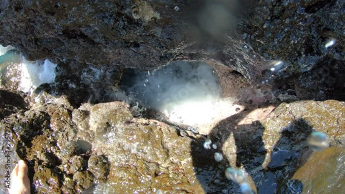 Ocean Water Spout Sprays Camera Waave Crashing Through Hole in Volcanic Lava Rock photo