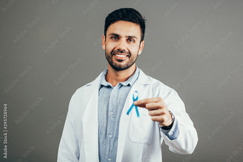 Prostate Cancer Awareness. Doctor man holding light Blue Ribbon for supporting people living and illness. Men Healthcare and World cancer day concept Prostate Cancer Awareness. Doctor man holding light Blue Ribbon for supporting people living and illness. Men Healthcare and World cancer day concept