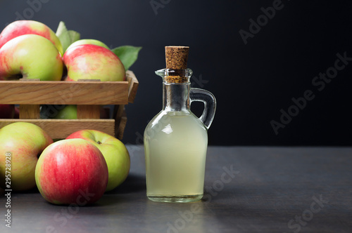 Fototapeta Naklejka Na Ścianę i Meble -  Glass bottle of handmade organic apple cider vinegar made from fermented fresh ripe apples. Healthy organic food, selective focus, space for text