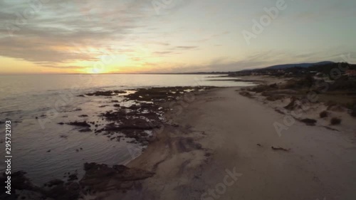 Wallpaper Mural A drone shot at sunset of Playa Hermosa, in Piriapolis, Maldonado, Uruguay. The drone flies up and away from the calm water rippling to the shoreline in the calm evening. Torontodigital.ca