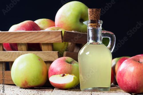 Glass bottle of handmade organic apple cider vinegar made from fermented fresh ripe apples. Healthy organic food