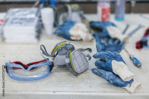 safety goggles, respirator and gloves on factory table
