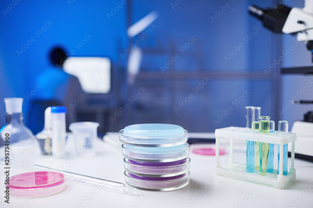 Close up of assorted glassware and test tubes and petri dishes on table in medical laboratory, copy space Close up of assorted glassware and test tubes and petri dishes on table in medical laboratory, copy space