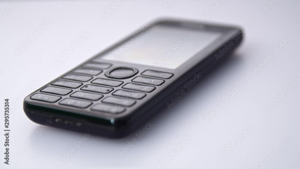 Close Up old Nokia 310 phone on a white table. Tracking left shot Close Up old Nokia 310 phone on a white table. Tracking left shot