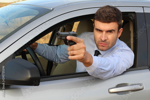 Secret agent holding gun while driving