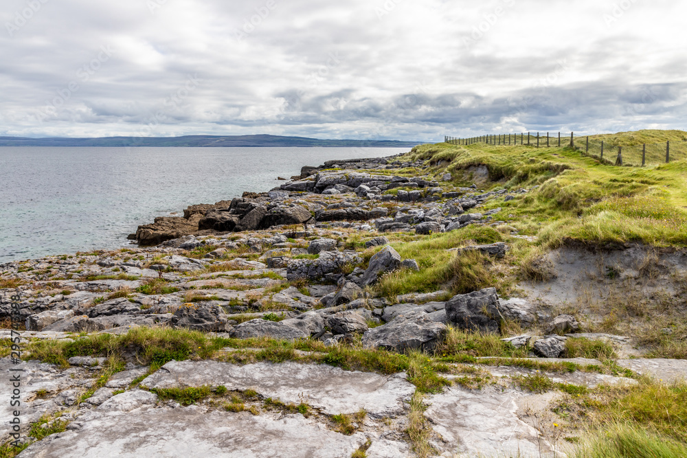 Rocks and field in Inisheer Island with burren in background Rocks and field in Inisheer Island with burren in background