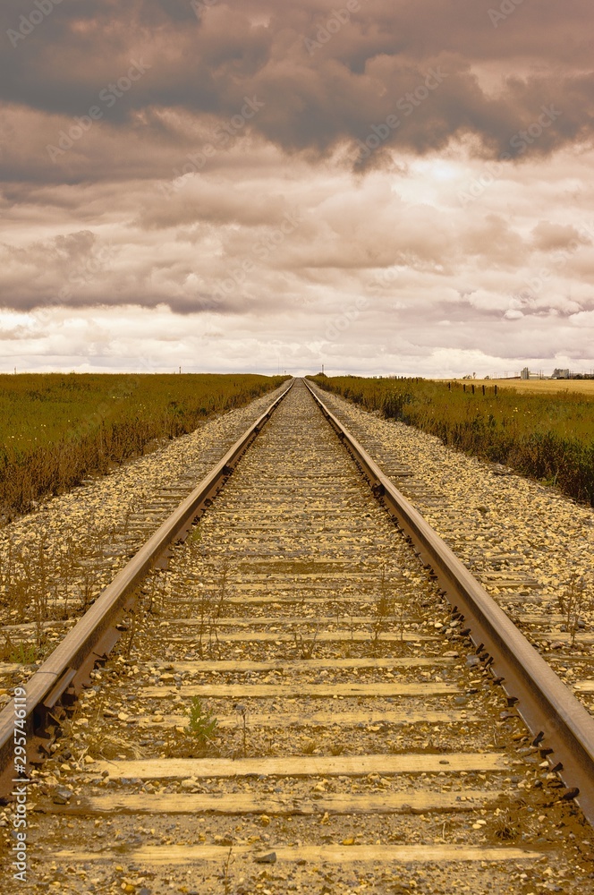 Railroad tracks running into a distant cloudy horizon Railroad tracks running into a distant cloudy horizon