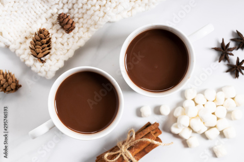 White ceramic cups of hot cocoa on top of white marble background, top view