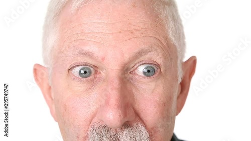 Senior man rolling his eyes to look around; close-up of eyes