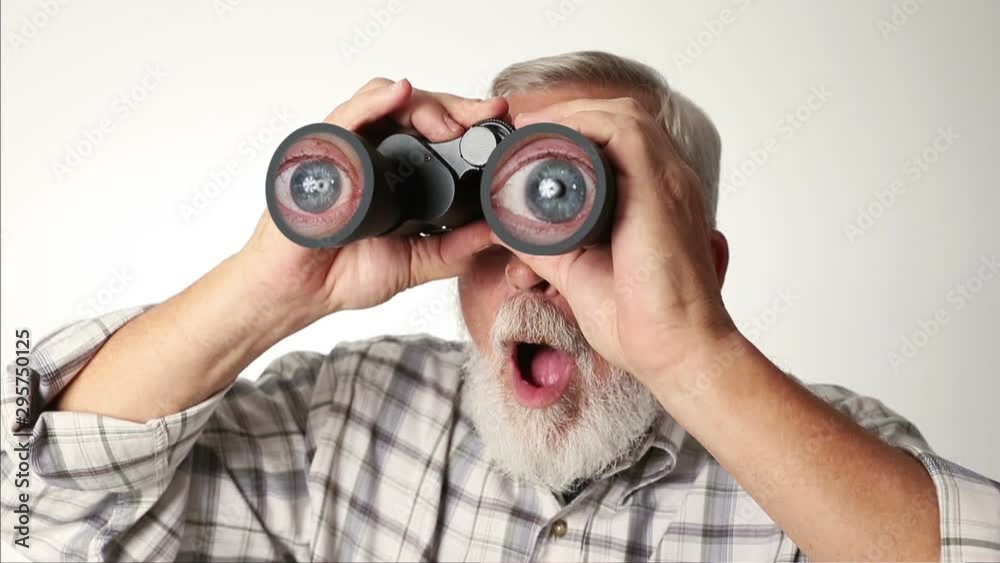 Senior adult male looking through binoculars with a surprised expression on his face. Senior adult male looking through binoculars with a surprised expression on his face.