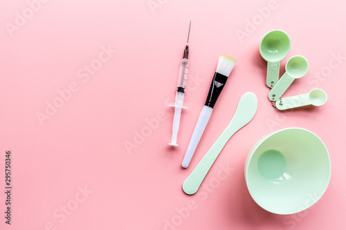 Tools set and injector for home or salon facial skin care on pink background, top view, flat lay. Serum, face mask. Mockup. Skin care concept