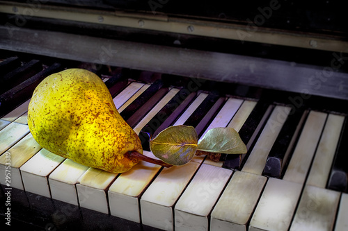 Una pera sobre un antiguo piano