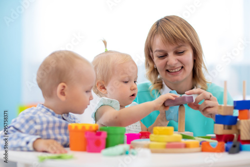 Little caucasian baby playing with Montessori toy in creche or pre-school