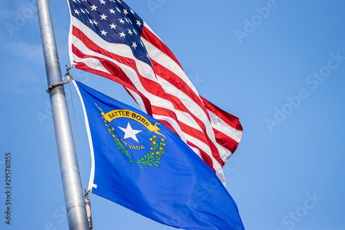 US Flag and Nevada state flag flying in slow motion photo