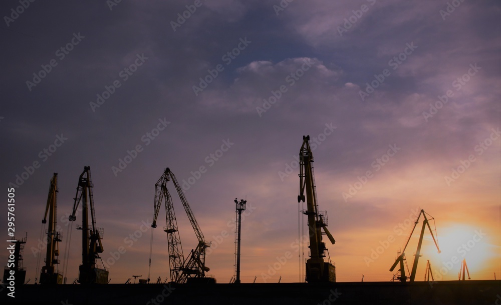 silhouette of harbor cranes in evening