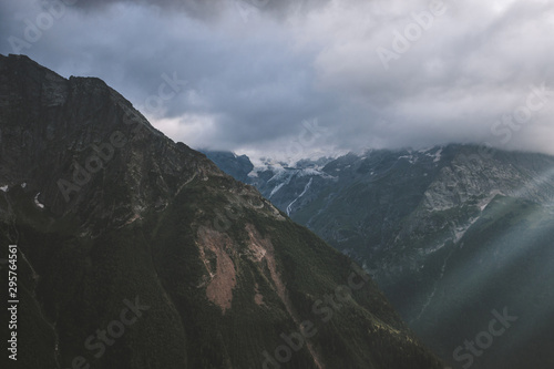 Panorama of misty mountains scene with dramatic sky in national park of Dombay