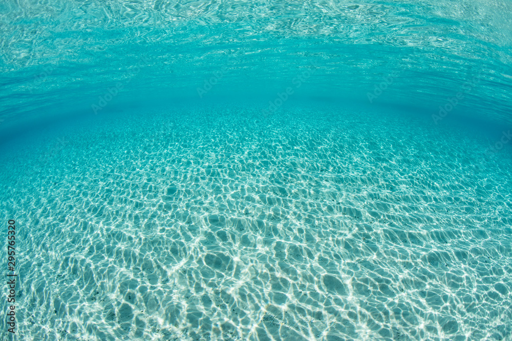Bright sunlight ripples across a sandy seafloor in the tropical Pacific Ocean. Bright sunlight ripples across a sandy seafloor in the tropical Pacific Ocean.