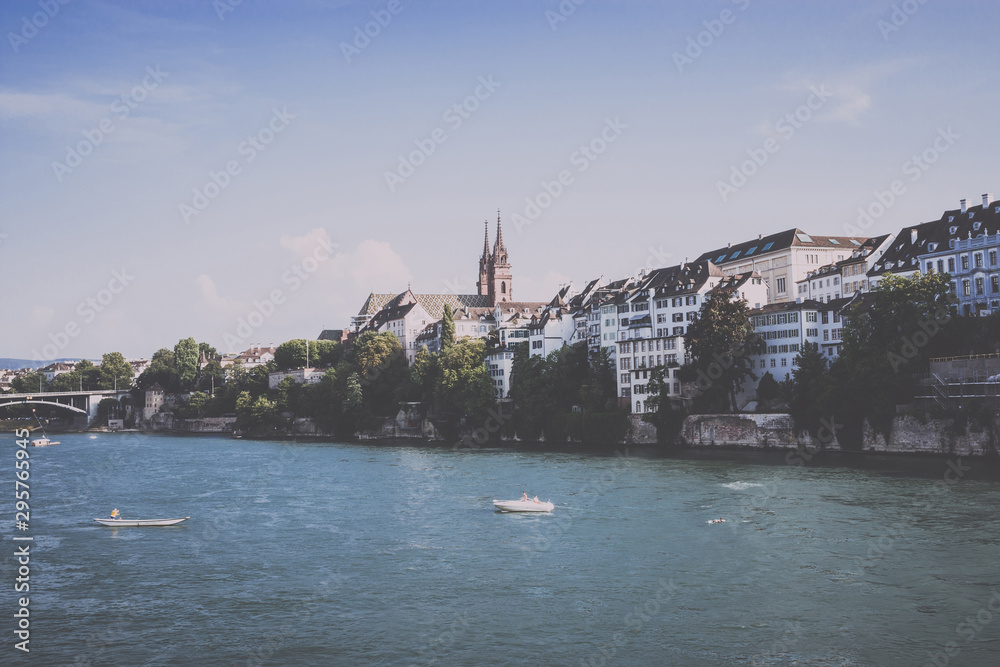 Fototapeta premium View on Basel city and river Rhine, Switzerland. People swim in water