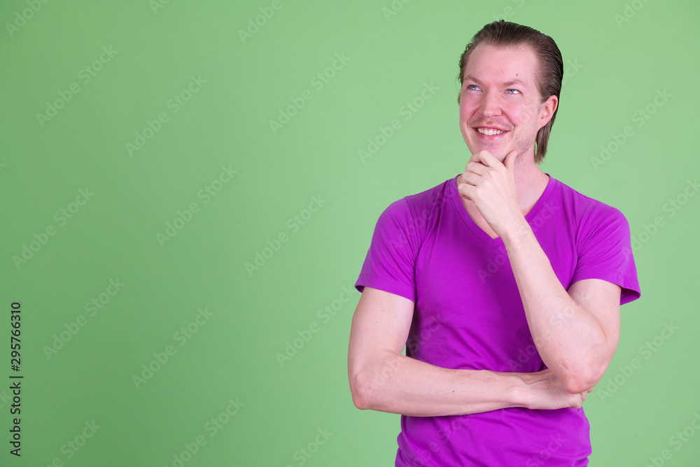 Portrait of happy young handsome man thinking and looking up Portrait of happy young handsome man thinking and looking up