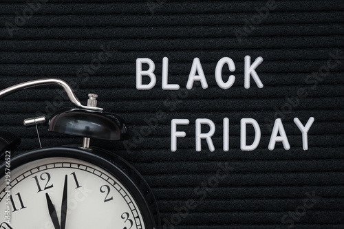 White text Black friday on black letter board and alarm clock , closeup. Concept Black friday , season sales time. Flat lay Top view Copy space Template layout for your design