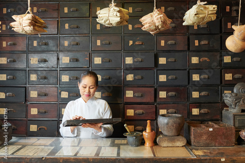 Obraz na plátně Traditional Chinese medicine practitioner using abacus for counting ingredients