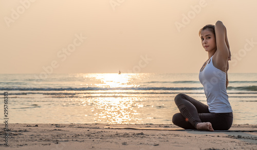 Asian yoga woman doing exercise on the beach.