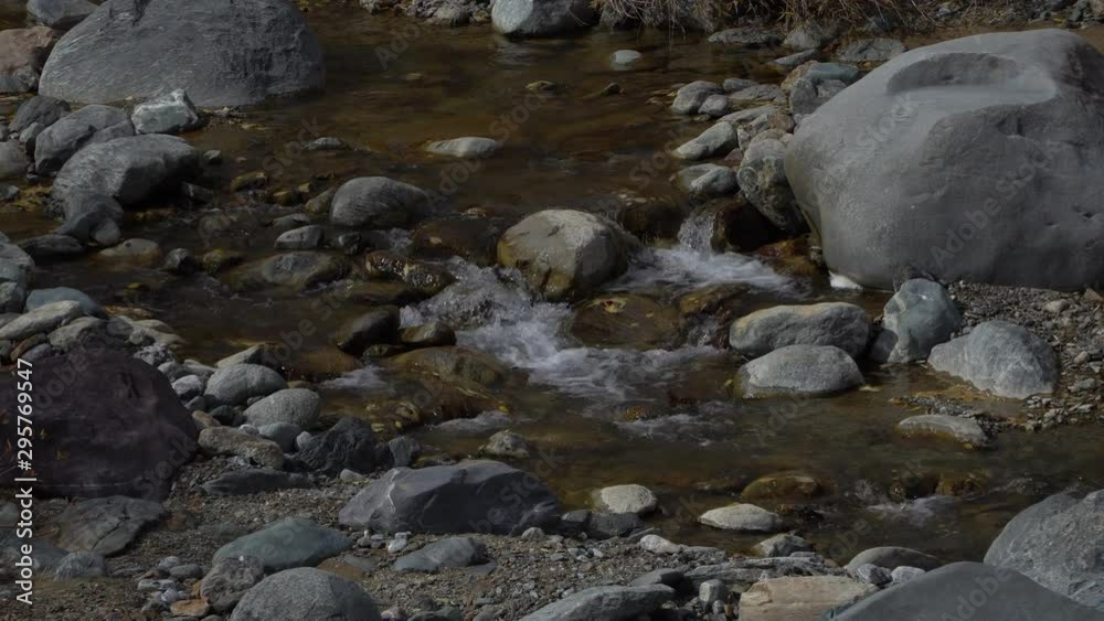 Stones in the mountain river. Water stream creek and gray rocks close-up. Stones in the mountain river. Water stream creek and gray rocks close-up.