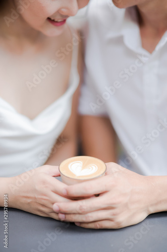 Lovely couple holding cup of coffee in hands. love concept