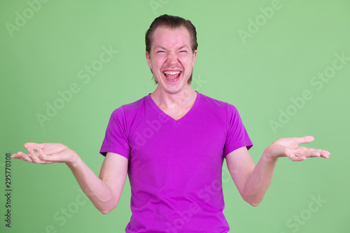 Portrait of happy young handsome man comparing something