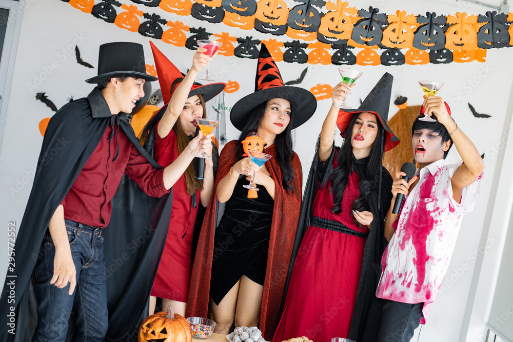 Obraz premium Gang of teen Asian celebrate Halloween for sing a song and drink, dessert in the room.