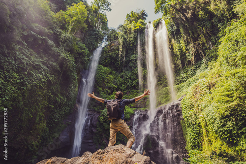 Man in turquoise dress at the Sekumpul waterfalls in jungles on Bali island, Indonesia. Bali Travel Concept