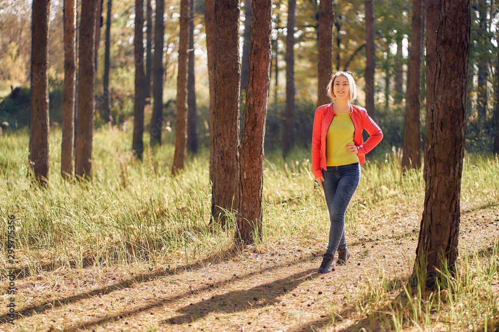 young woman walks in the autumn forest at sunset young woman walks in the autumn forest at sunset