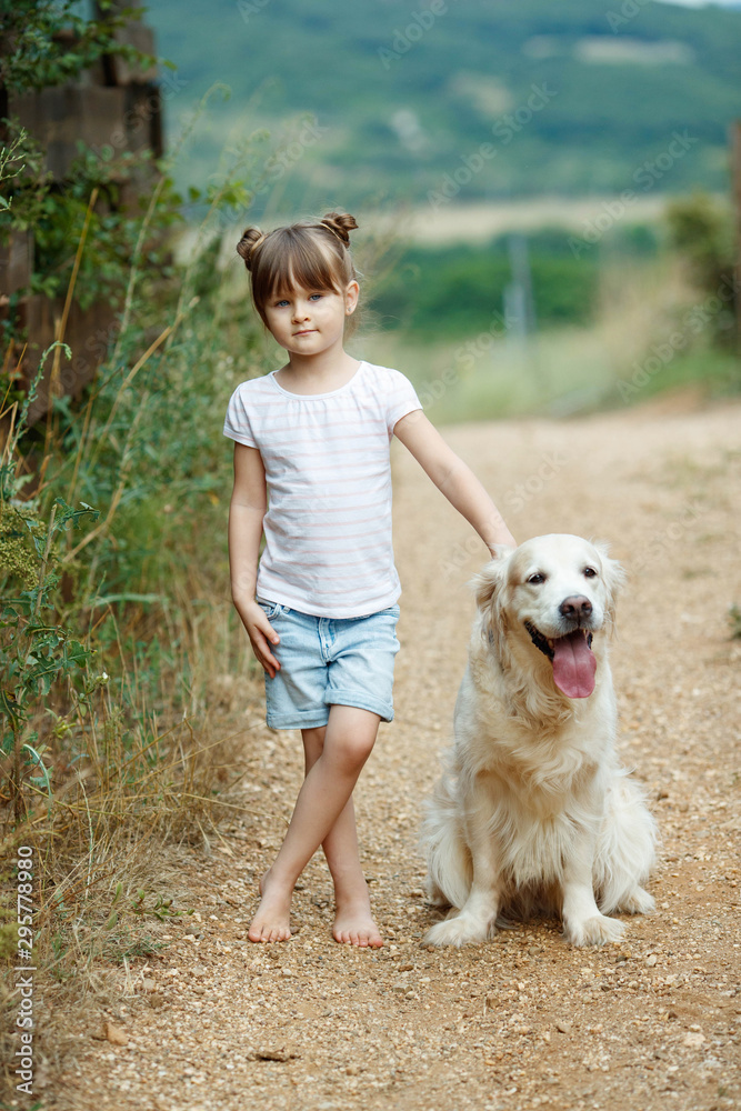 A child with a dog. Little girl plays with a dog in nature. A child with a dog. Little girl plays with a dog in nature.