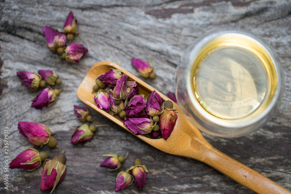 Buds of dried roses for tea in a spoon wooden Buds of dried roses for tea in a spoon wooden