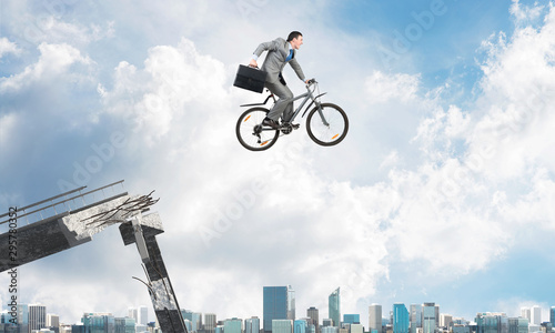Man on bike jumping from broken bridge © adam121