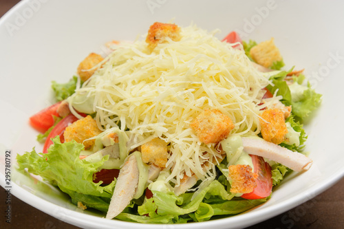 Chicken salad with cheese and crackers on the white dish. Closeup