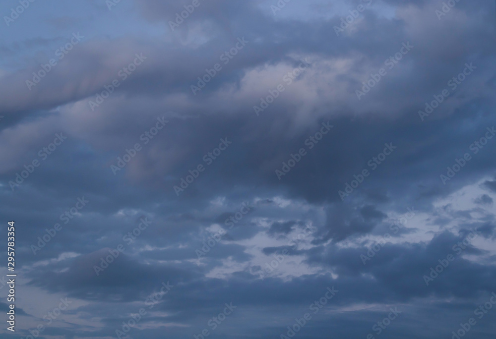 Fototapeta premium Dark blue beautiful sky with high fluffy clouds in twilight