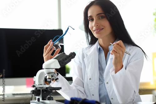 Pretty woman holding glasses for experiments