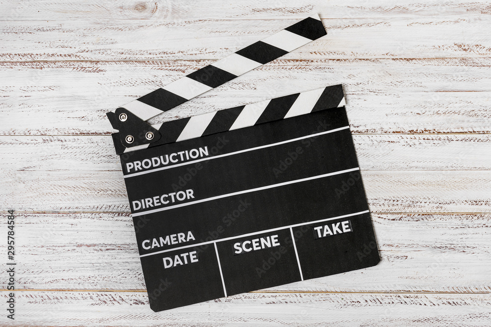 Obraz premium An elevated view on clapperboard over white wooden desk