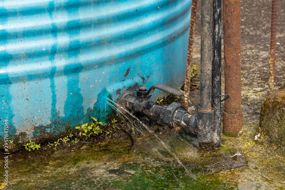 Water leakage from crack in water tank installed in house rooftop. Stock  Photo | Adobe Stock
