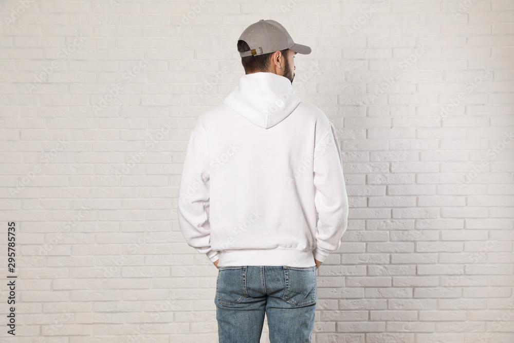 Young man in sweater at brick wall. Mock up for design Young man in sweater at brick wall. Mock up for design