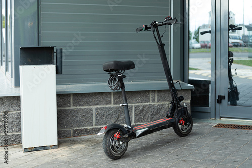 Modern electroscooter standing near entrance to office building photo