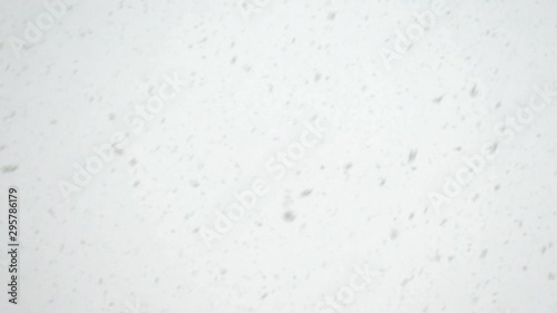 Snow is falling fast against the sky.