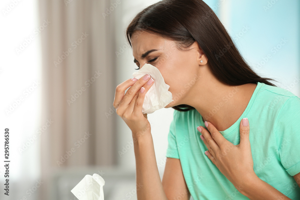 Young woman suffering from allergy at home