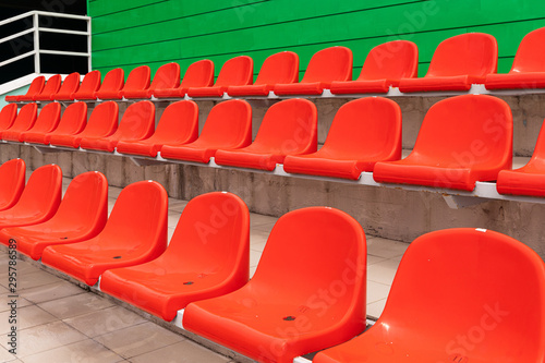 Rows of red diagonal spectator seats with no people in it
