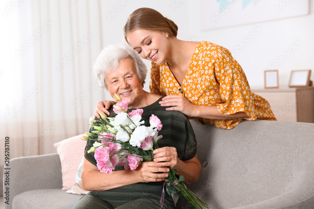 Young woman congratulating her senior mom at home. Happy Mother's Day Young woman congratulating her senior mom at home. Happy Mother's Day