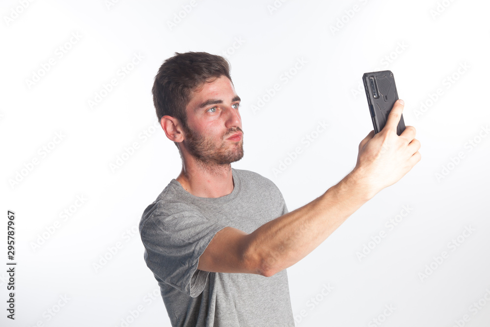 Joven haciéndose un selfie con un teléfono inteligente Joven haciéndose un selfie con un teléfono inteligente